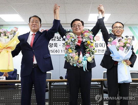 서울시교육감 보궐선거에 보수 단일 후보로 추대된 조전혁 전 한나라당 의원(가운데)이 안양옥(왼쪽)과 홍후조 후보의 축하를 받으며 손을 맞잡고 있다. 연합뉴스